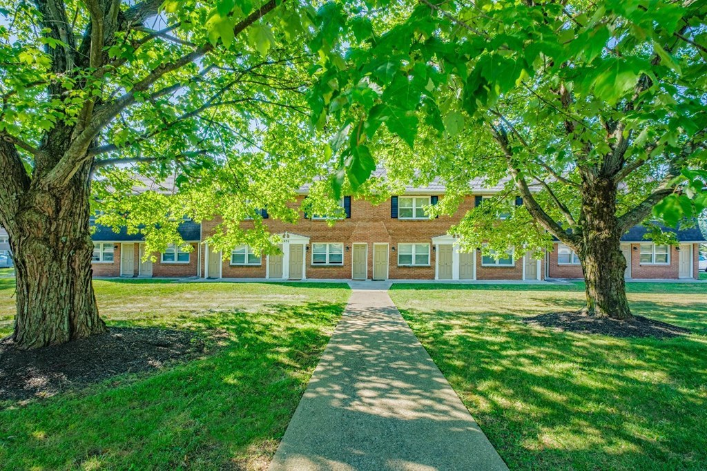 A building is surrounded by trees and a walkway.