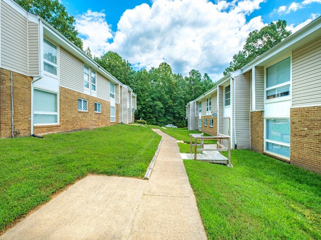 A row of houses with a concrete pathway leading to a picnic table.