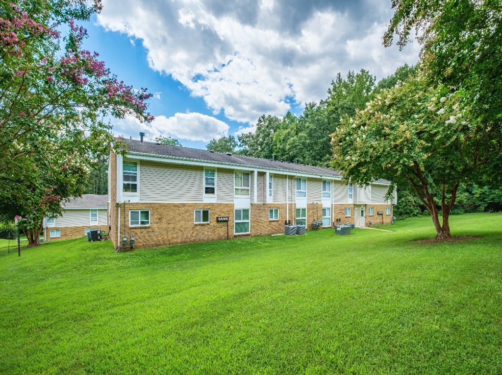 A large grassy area in front of a two story building.