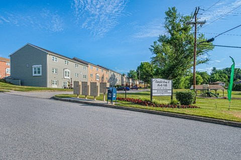 A street view of a residential area with a sign for "Campbell Court" and a green flag.
