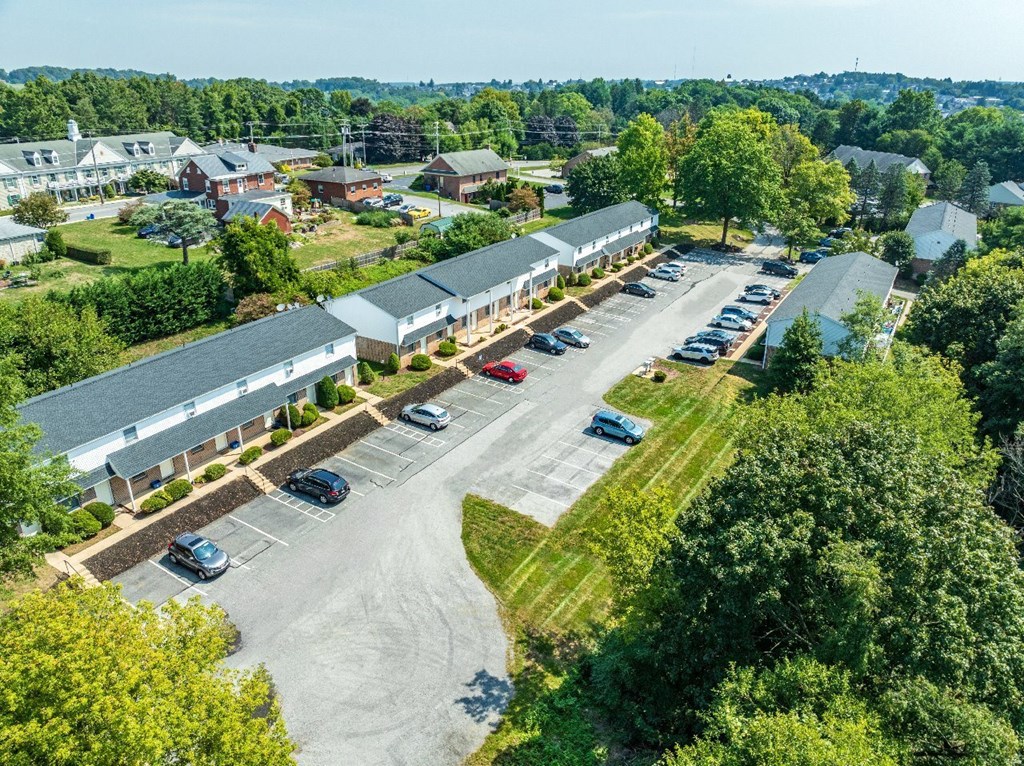 A parking lot with cars and a building in the background.