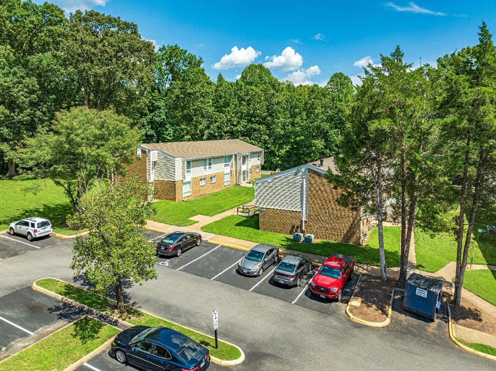 A parking lot with cars and a building in the background.