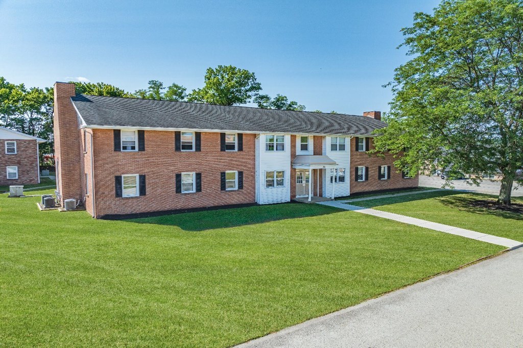 A red brick building with a white door and windows.