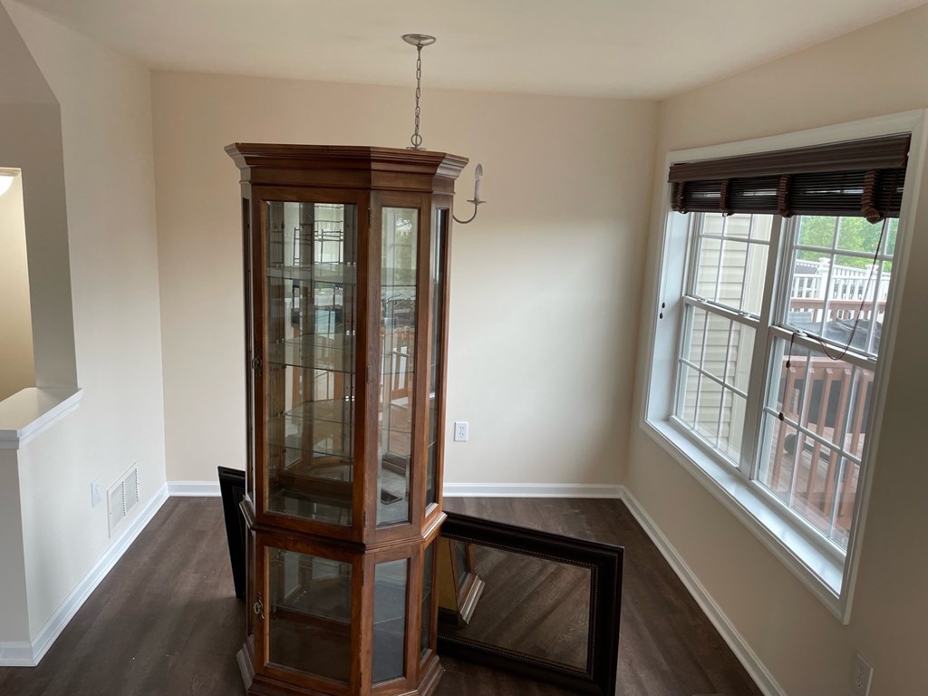 A wooden cabinet with glass doors is in the corner of a room.