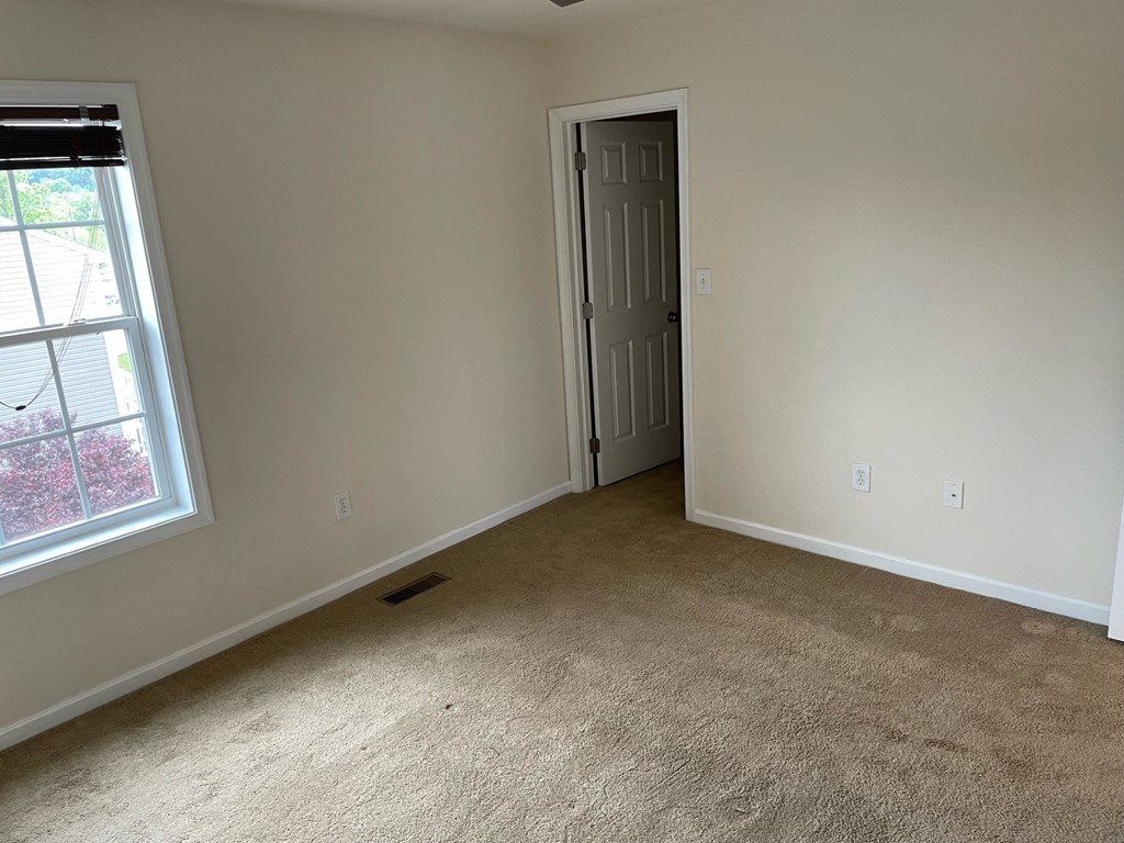 A room with a carpeted floor and a door.