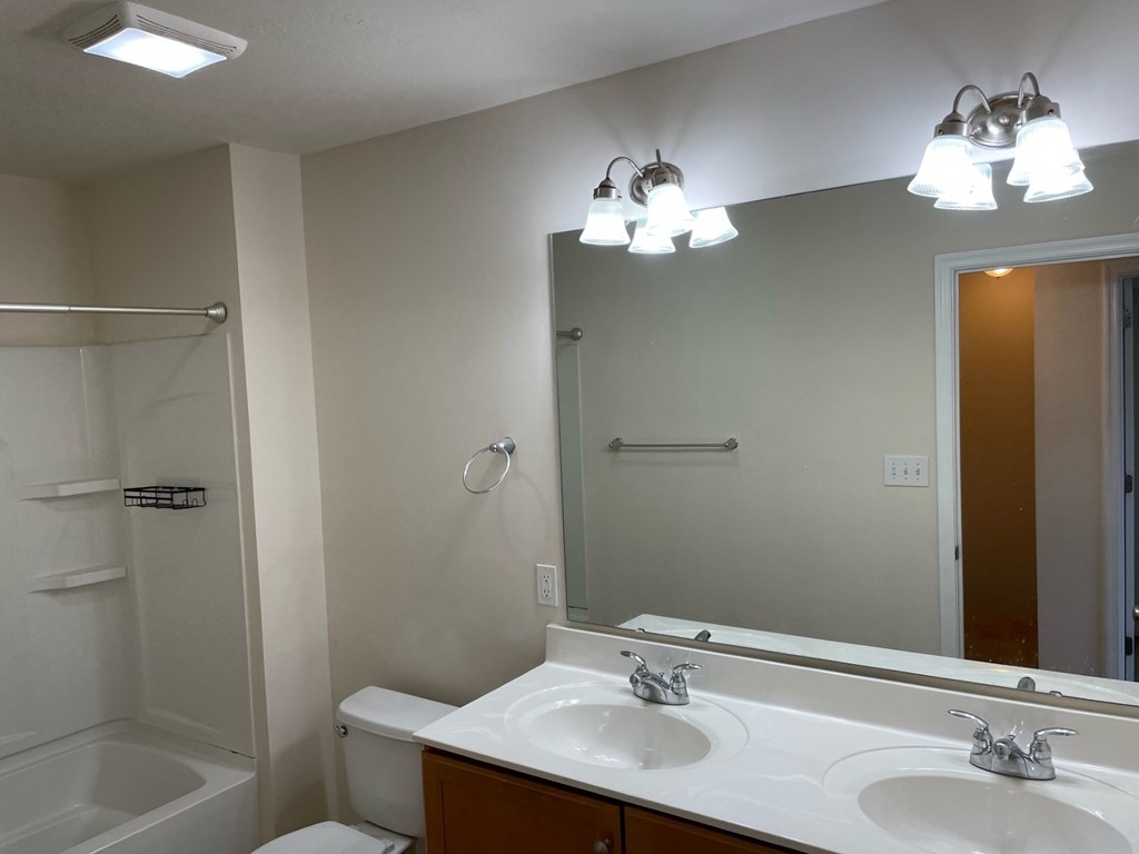 A bathroom with a white sink and a white toilet.