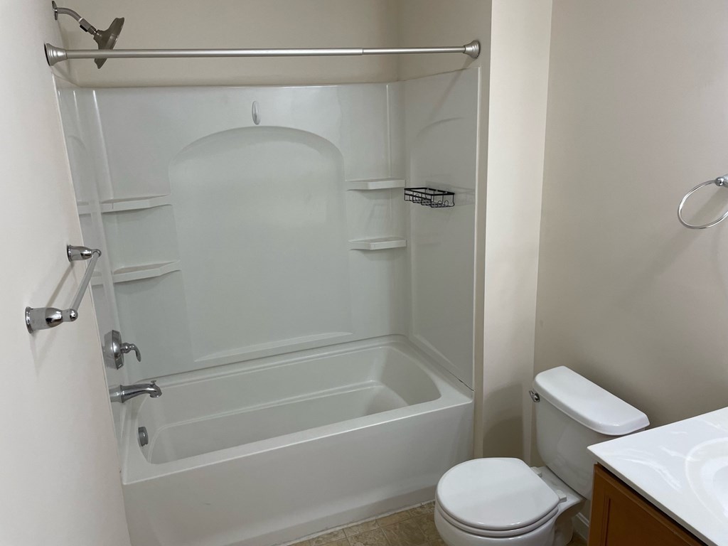 A white bathroom with a toilet, sink, and bathtub.