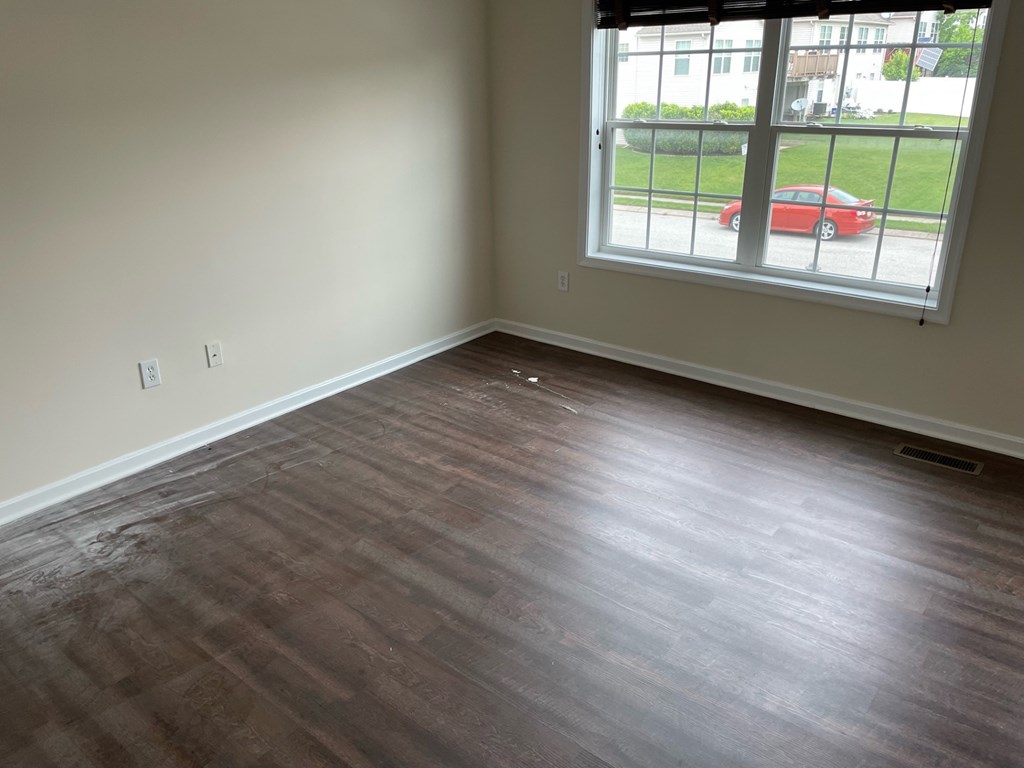 A room with a window and a red car outside.