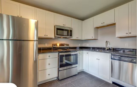 A modern kitchen with stainless steel appliances and white cabinets.