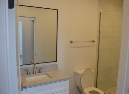A white toilet sits next to a sink in a bathroom.