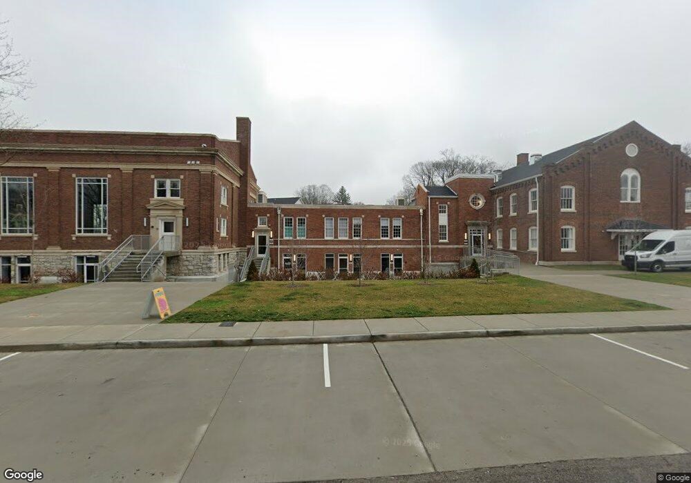 A large brick building with a parking lot in front.