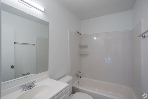 A white bathroom with a sink, toilet, and bathtub.