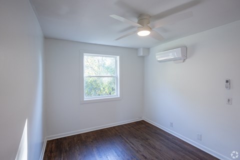 A room with a window and a ceiling fan.
