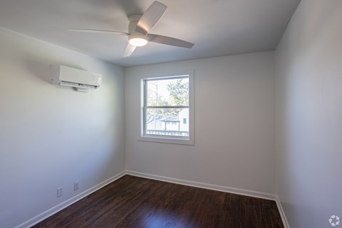 A room with a ceiling fan and a window.