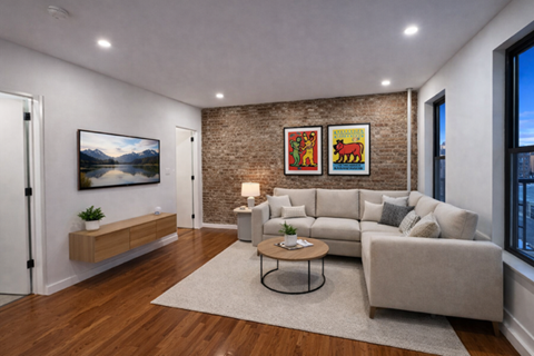 A living room with a white couch, a coffee table, and a brick wall.