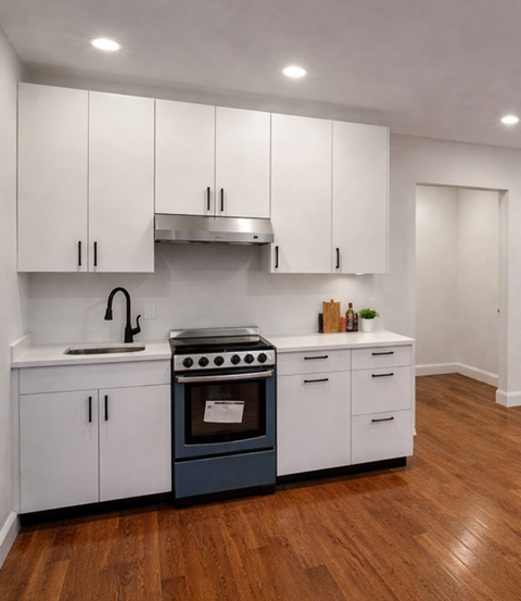 A kitchen with white cabinets and a blue stove top oven.
