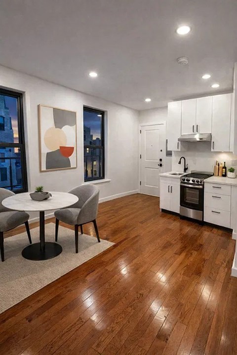 A modern kitchen with a round table and chairs.