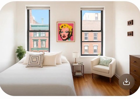 A bedroom with a bed, chair, and a painting of a woman's face on the wall.