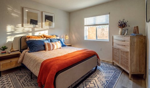A bedroom with a bed, dresser, and mirror.