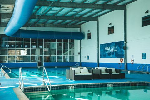 A pool with a sign that says "Move Well" on the wall.