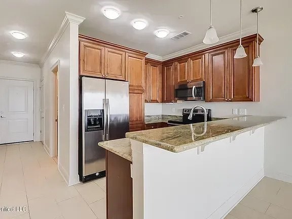 A kitchen with brown cabinets and a marble countertop.