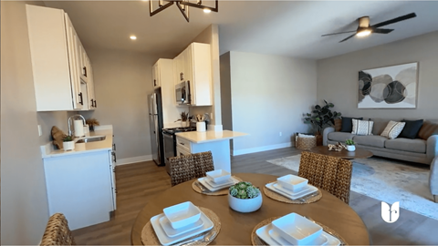 A modern kitchen with a dining table set for two.