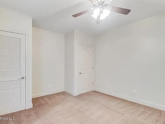 A room with a ceiling fan and two doors.