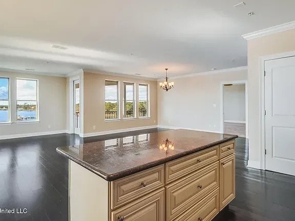 A kitchen with a brown countertop and wooden cabinets.