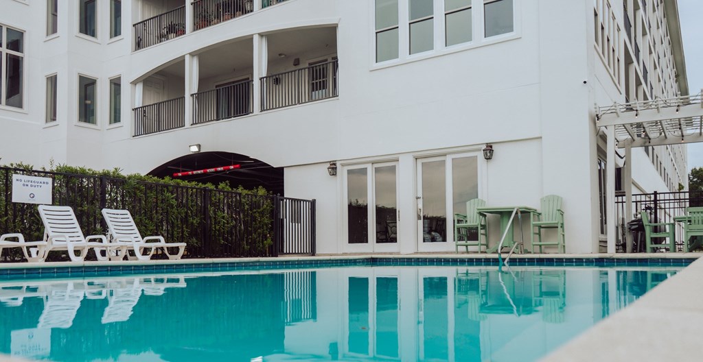 A white building with a pool in front.
