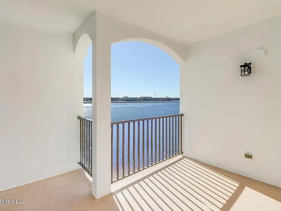A balcony with a view of the water and sky.