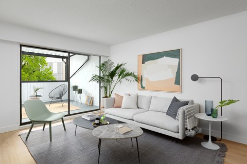 A living room with a white couch, a green chair, and a painting on the wall.