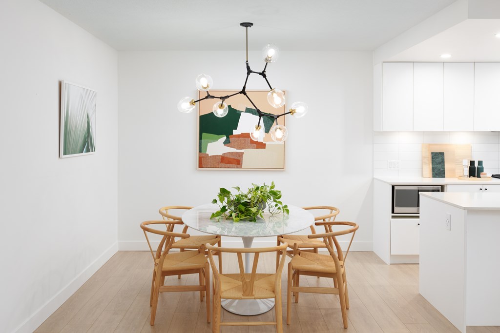 A dining room with a white table and chairs.