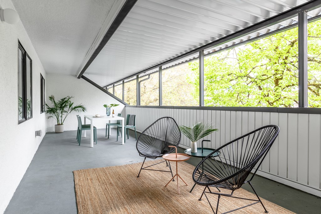 A room with a white table and chairs with a brown rug in front of it.