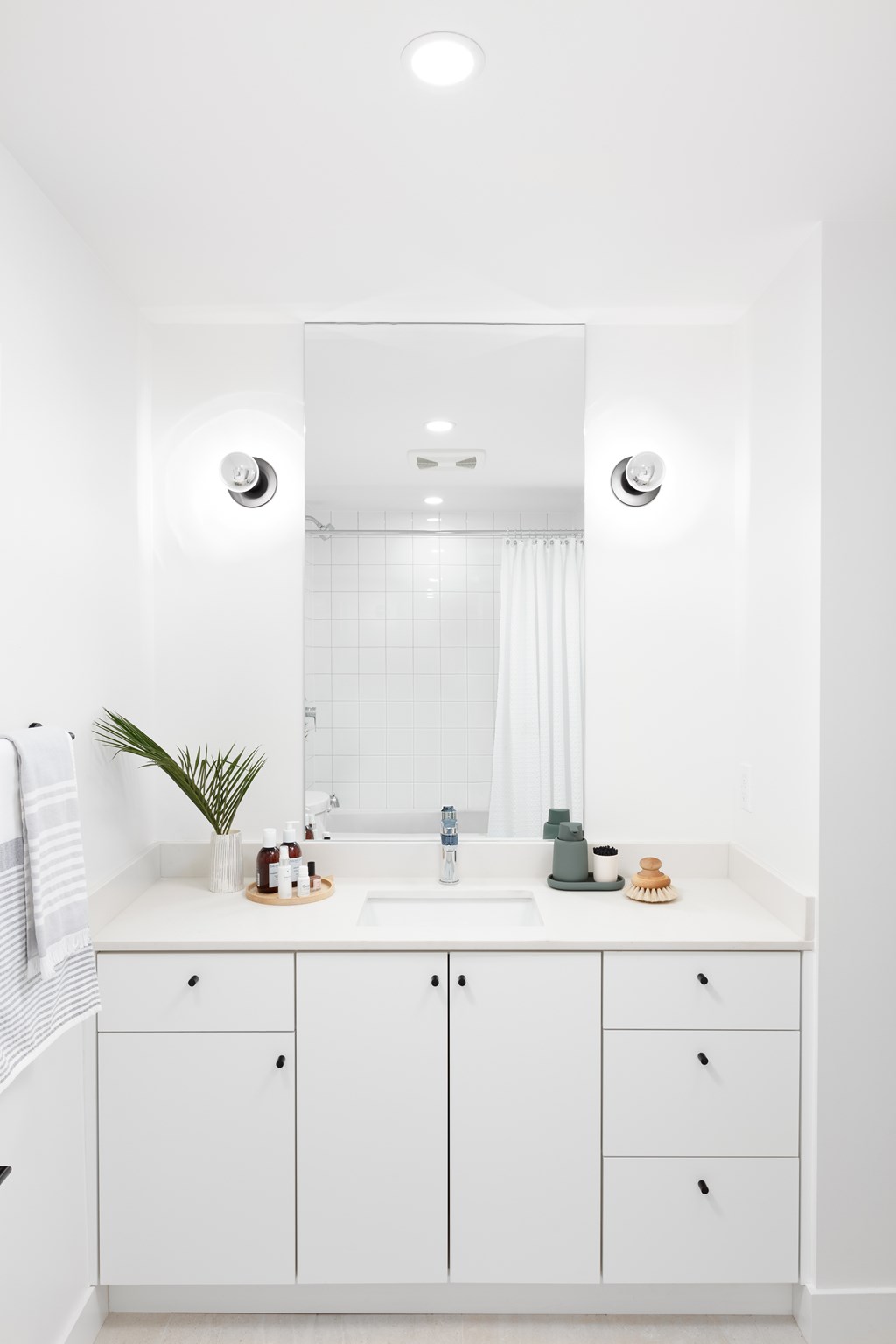 A white bathroom with a sink and mirror.