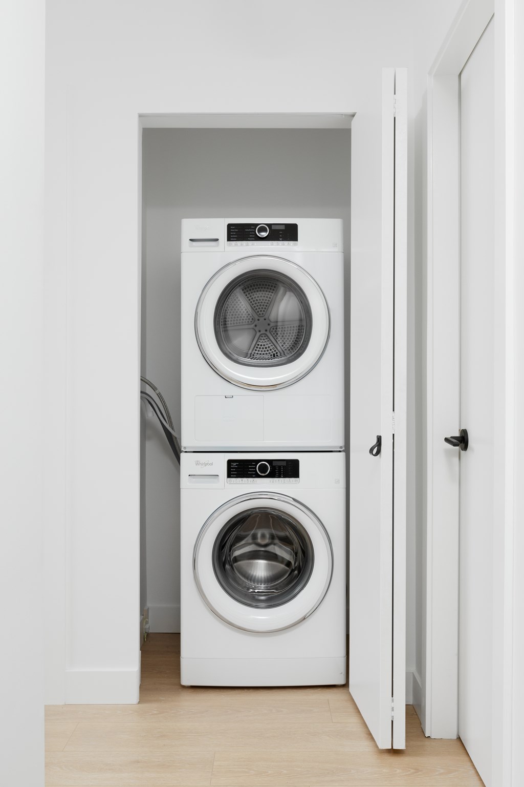 A white washing machine and dryer in a small laundry room.