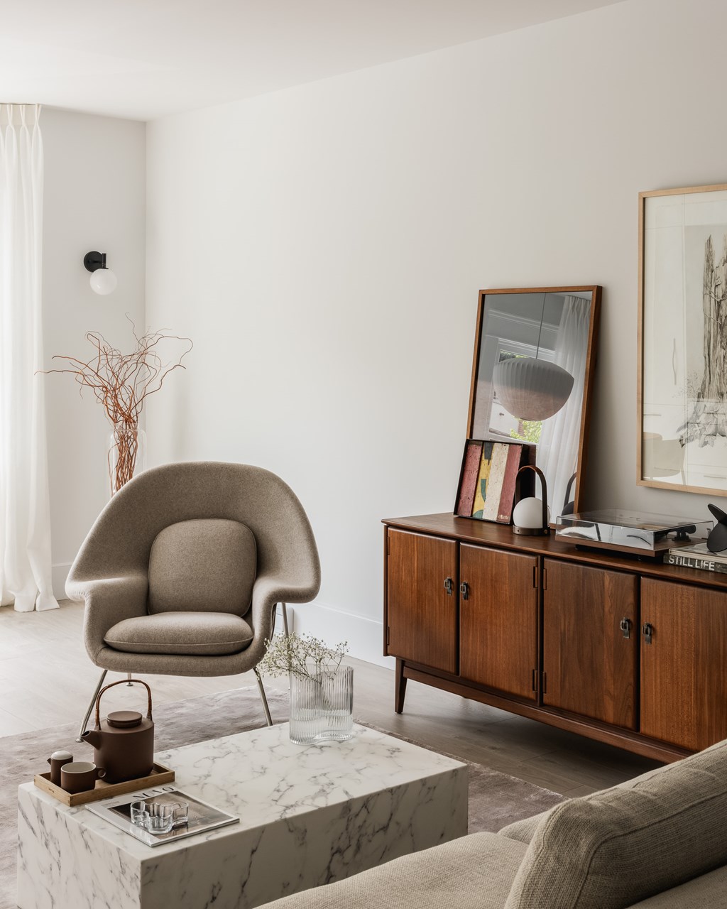A chair sits on a marble table in a room with a wooden cabinet and a framed mirror.