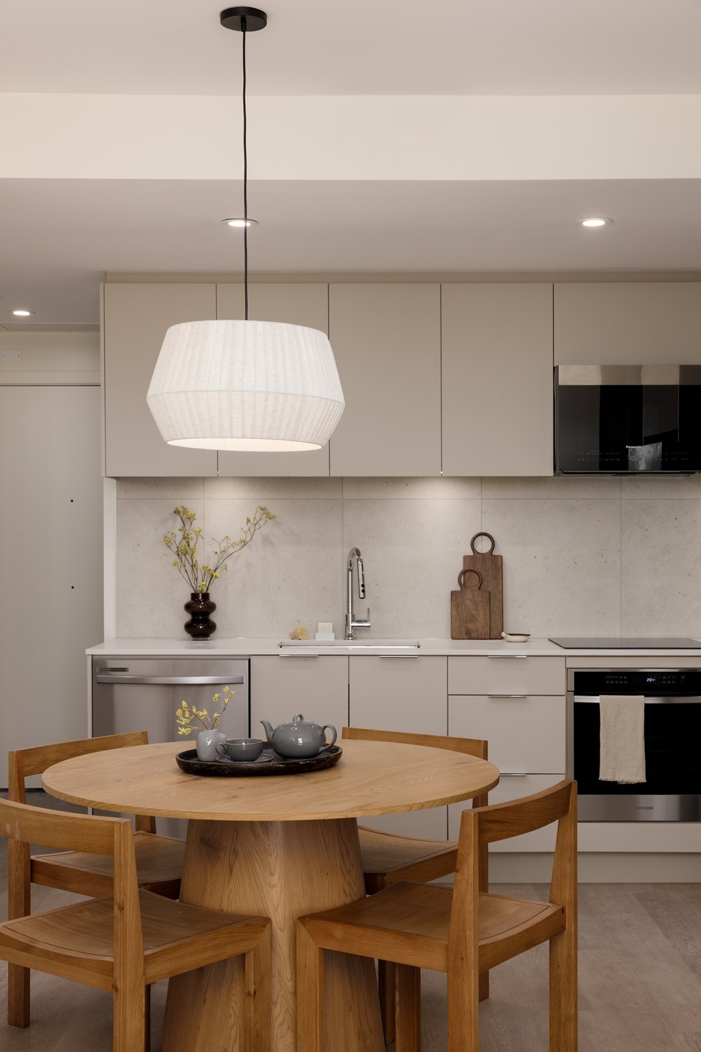 A modern kitchen with a wooden table and chairs.