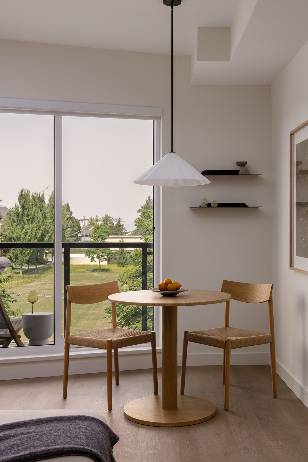 A table with two chairs and a bowl of fruit on it.