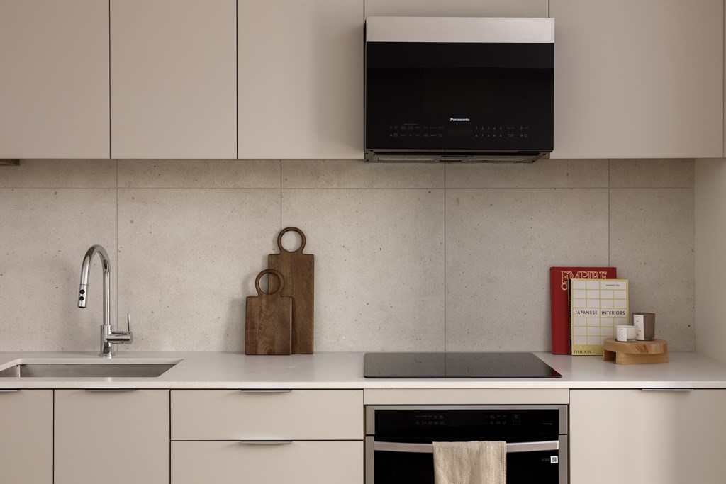A kitchen with a white countertop and a black oven.