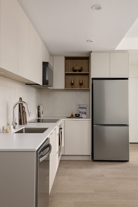 A modern kitchen with a stainless steel refrigerator and a white countertop.
