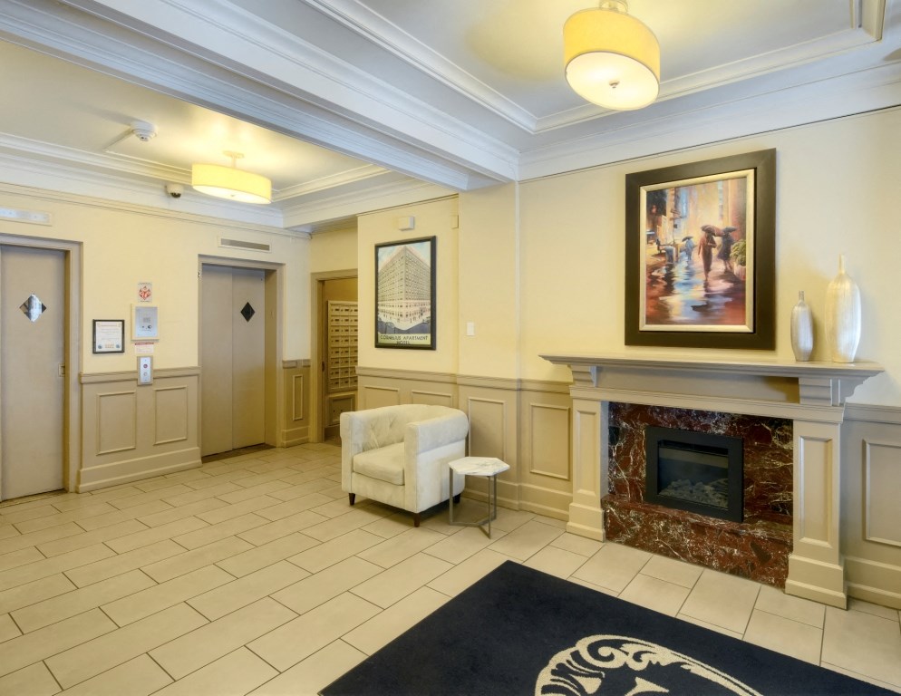 A lobby with a fireplace and a painting on the wall.