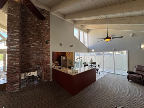 A kitchen area with dining table sits next to a fireplace.