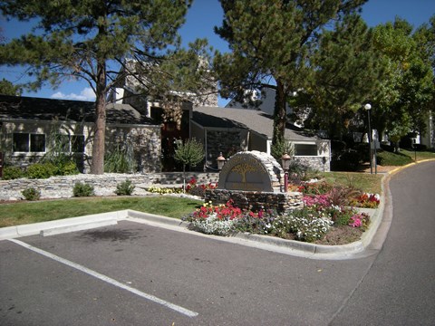 A stone monument is in the middle of a flower bed.