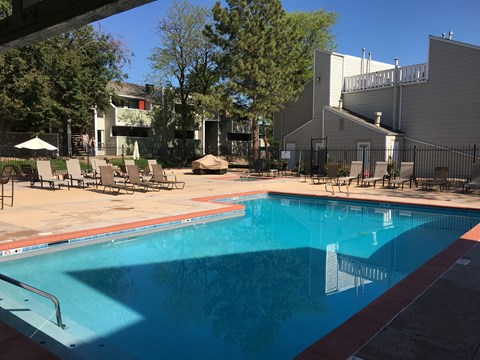 A swimming pool with a red border and a metal fence around it.