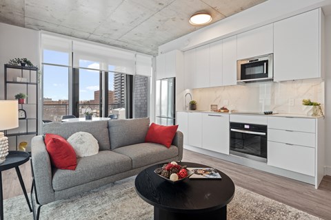 A modern living room with a grey couch and a black coffee table.