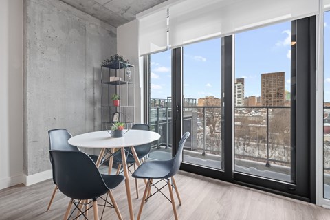 A dining room with a white table and black chairs.