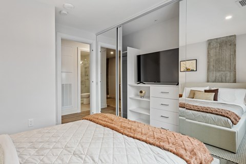 A bedroom with a bed, dresser, and mirror.