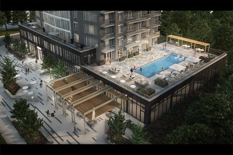 A modern building with a pool and a wooden deck.