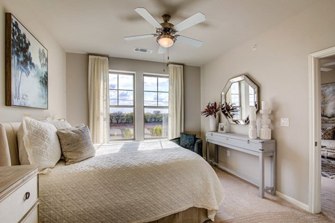 A bedroom with a large bed and a ceiling fan.