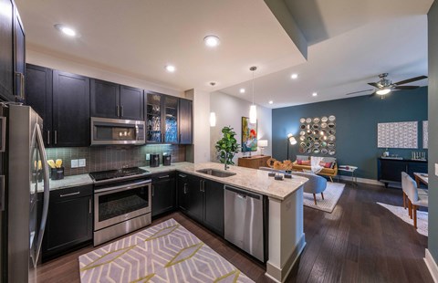 A modern kitchen with dark wood cabinets and stainless steel appliances.